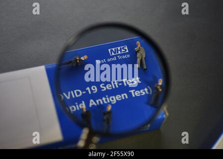 A COVID-19 Self Test (Rapid Antigen Test) kit information concept image. Selective focus through a magnifying glass. Stock Photo