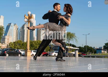 Male and female dancers looking at each other while practicing Tango dance on footpath Stock Photo