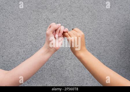 Hands of two women making pinky promise Stock Photo