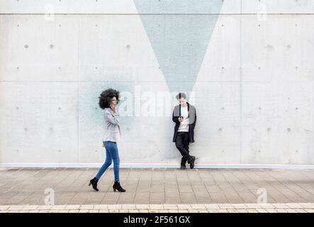 Graphic visualization of data sent by man and woman using smart phones outdoors Stock Photo