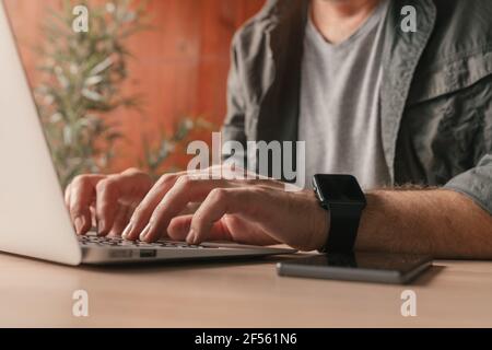 Freelancer working on laptop at home office, close up with selective focus Stock Photo