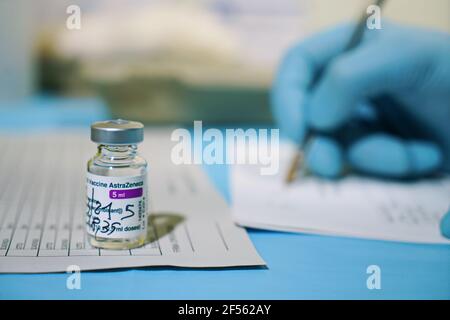 Vial of COVID-19 vaccine produced by AstraZeneca. Doctor's hand in a medical glove holds a bottle with a coronavirus vaccine. Selective focus. Turin, Stock Photo