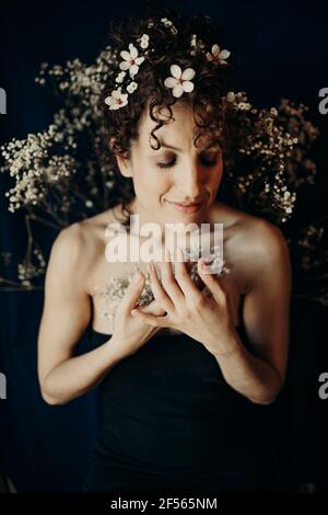Smiling woman with white flowers in hair Stock Photo
