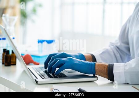 Male scientist working on laptop in laboratory Stock Photo