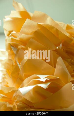 Low angle view of stacked golden yellow tissue paper flower abstract. Stock Photo