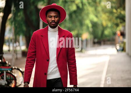 Confident fashionable man walking outdoors during sunny day Stock Photo