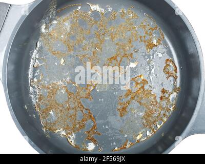 gray non-stick surface of a frying pan with burnt fried eggs top view, cookware for cooking fried food top view, nobody. Stock Photo