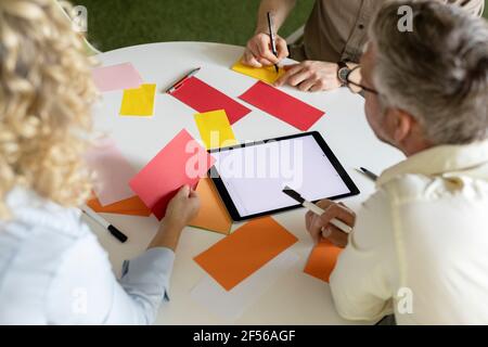 Male and female business professionals discussing over business plan at table in office Stock Photo