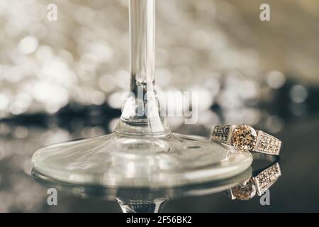 Close up of elegant diamond engagement ring isolated on black mirror background. Diamond ring. White gold ring with precious stone isolated on black. Stock Photo
