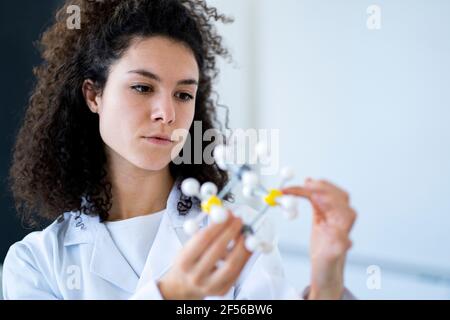 Female researcher examining molecular structure at chemistry lab Stock Photo