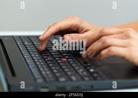 Human hand writting on laptop in office from close up Stock Photo
