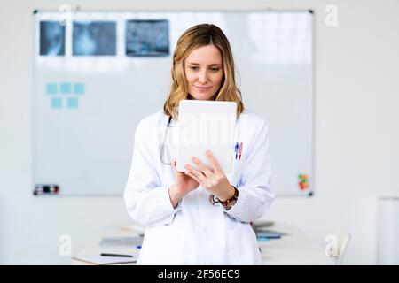 Female medical professional using digital tablet at home Stock Photo