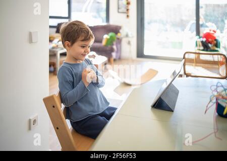 Boy learning through digital tablet at home Stock Photo