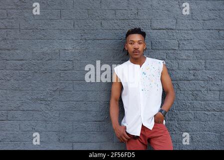 Portrait of urban african man leaning against gray wall Stock Photo