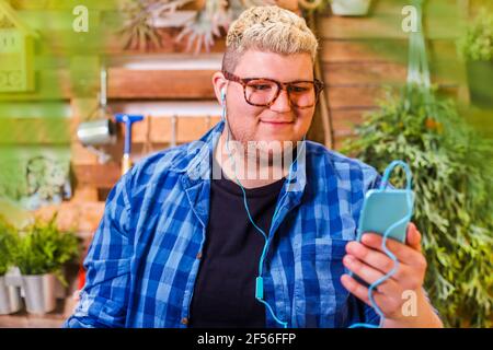 Young man using smartphone in his urban garden Stock Photo