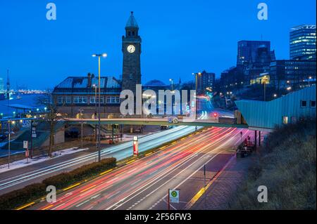 Germany, Hamburg, Vehicle light trails in front of Saint Pauli Piers clock tower at dawn Stock Photo