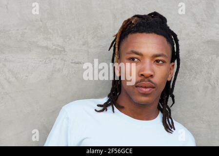Close up portrait of african man with dreadlocks glancing away Stock Photo