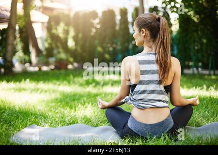 Girl practicing yoga in her backyard before going to work. Early wake ups are healthy. Stock Photo