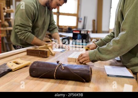 Craftsmen working at table in workshop Stock Photo