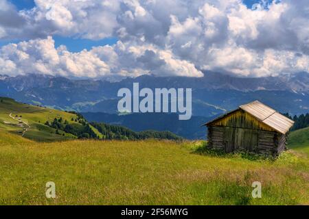 Dramatic clouds over lone hut at Odle mountain range during summer Stock Photo