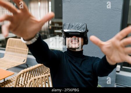 Businessman using virtual reality headset while sitting at cafe Stock Photo