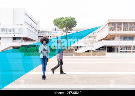 Graphic visualization of facial recognition effects covering man and woman using smart phones outdoors Stock Photo