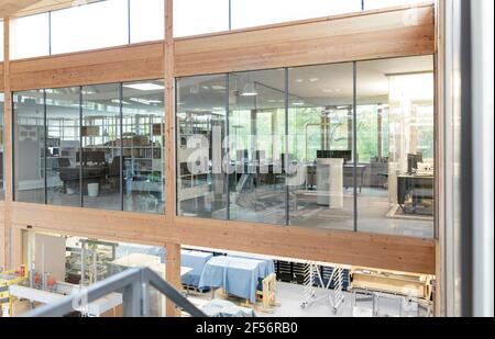 Empty office floor seen through glass walls in factory Stock Photo