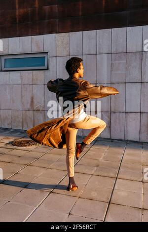 Man spinning while practicing dance against building Stock Photo