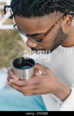 Young man drinking hot tea from cup Stock Photo