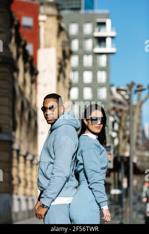 Young couple standing back to back Stock Photo