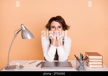 Photo of optimistic nice short hairdo girl sit hands face wear pullover isolated on peach color background Stock Photo