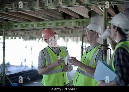 Smiling construction workers discussing at construction site Stock Photo