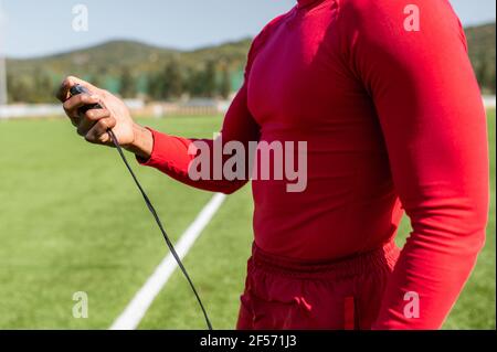 Unrecognizable coach holding a stopwatch to checking time in a football field. Stock Photo
