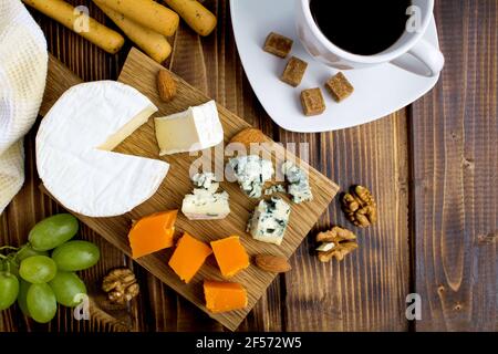 Snack  with cheeses and bread sticks on the brown  wooden background.Top view. Stock Photo