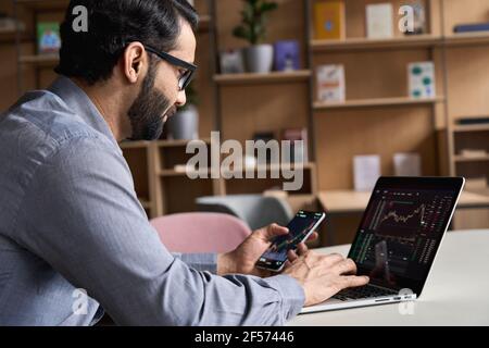 Indian business man trader investor analyst looking at financial market charts. Stock Photo