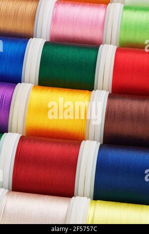 Background from spools with multi-colored sewing threads, photo stacking Stock Photo