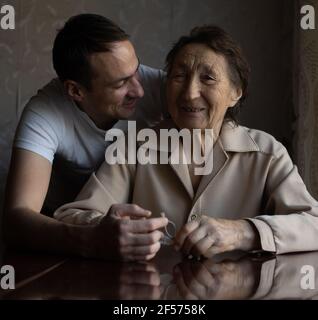 a very old woman and an adult grandson Stock Photo