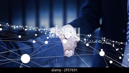 Composition of businessmen shaking hands with network of connections Stock Photo