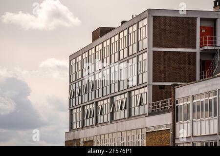 Old 1970's concrete and brick office building block with sun shining in need of regeneration project to modernise Stock Photo