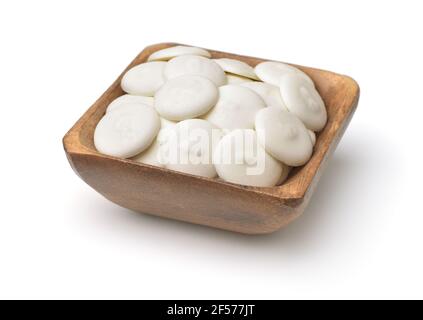 Wooden bowl of white chocolate buttons isolated on white Stock Photo