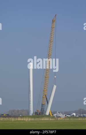 A crawler crane is hoisting the tower of a new wind turbine Stock Photo