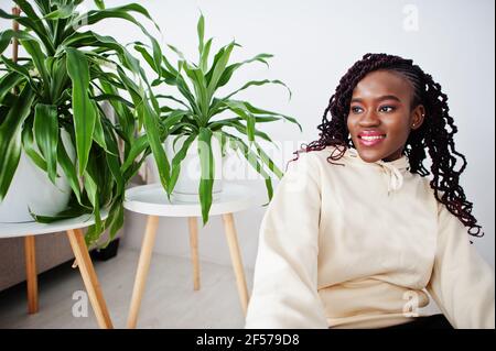 African woman sitting near greenery at home Stock Photo - Alamy