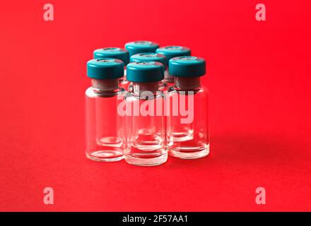 Several empty medical vials on red background. Stock Photo