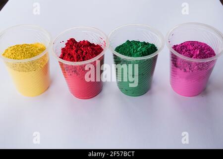 Organic colors in bowl used during Indian holi festivals. Holi colour powders vibrant pink, red, gren and yellow. White background blank space to writ Stock Photo