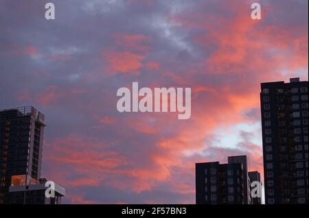 Amazing vibrant color sunset afterglow on the rain clouds over the city Stock Photo