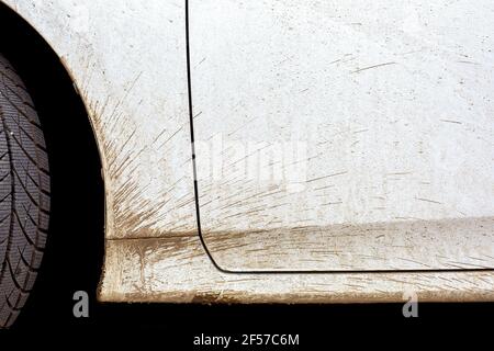 white dirty car in the splash of the slurry the driver door and the front fender of the vehicle closeup, nobody. Stock Photo