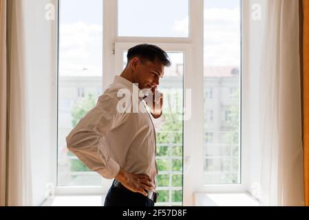 Relaxed young man resting from work. Man enjoy break stretching in home office workplace Stock Photo