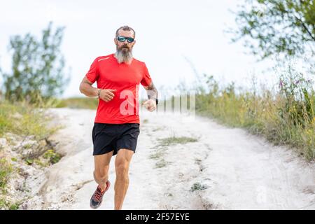 Bearded Men Racing Sporty bearded man running on the path at hillside Stock Photo - Alamy