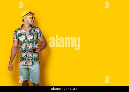 Man in bright clothes with beverage on yellow Stock Photo