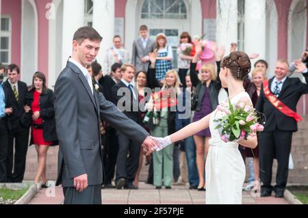 Petrozavodsk, Russia-circa May, 2010: Newlywed couple with members of the wedding stand on stairs of palace. The end of registration with guests congr Stock Photo